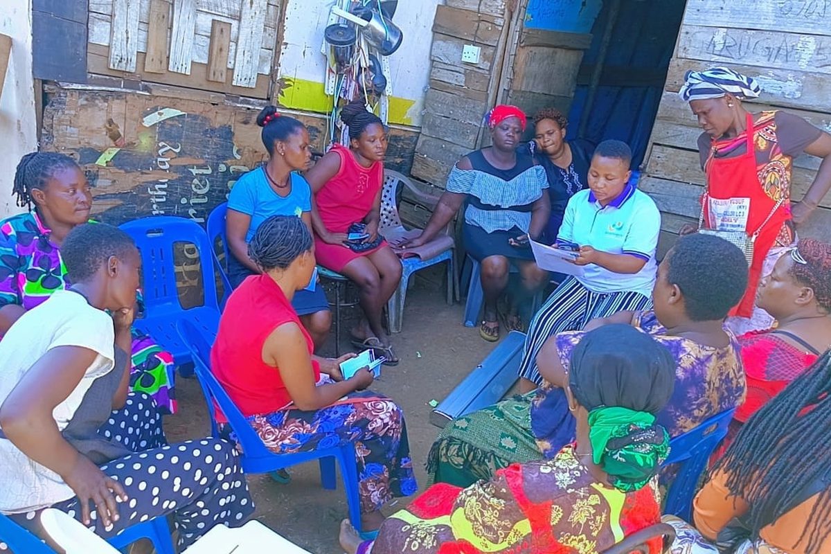 Women's group session in a courtyard in an informal settlement
